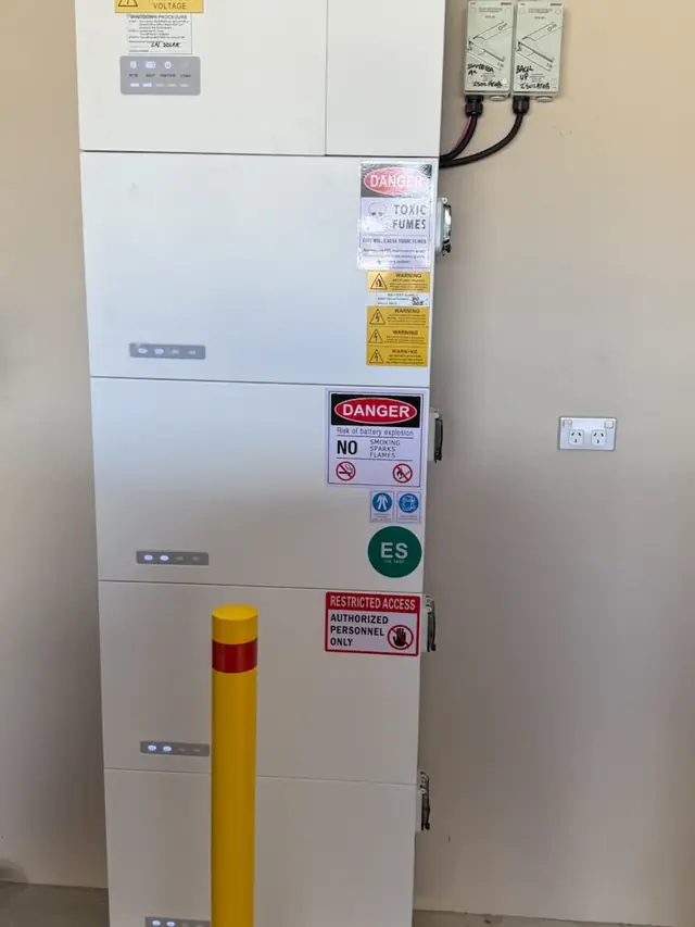 Stacked AlphaESS battery modules with compliance signage