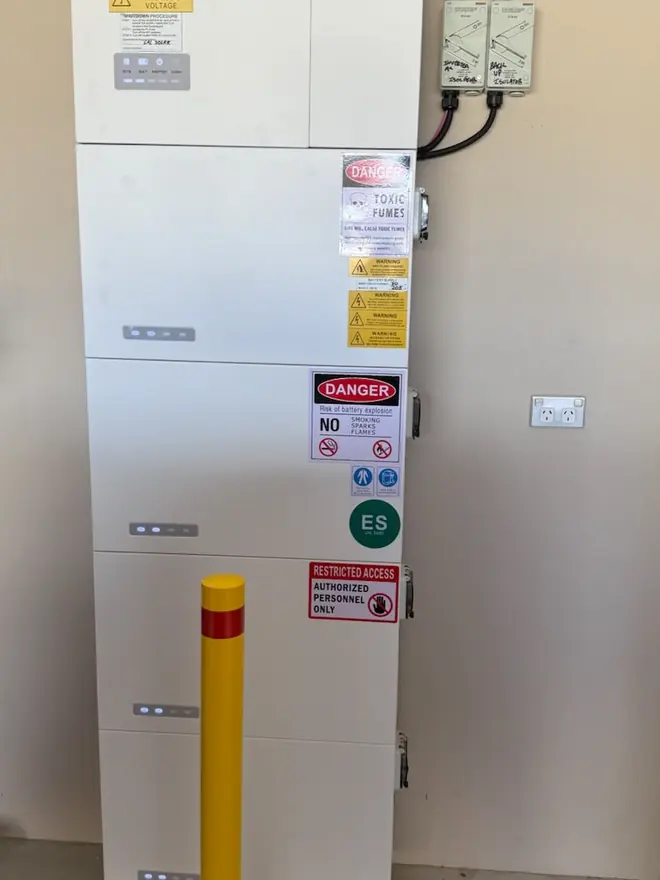 Stacked AlphaESS battery modules with compliance signage